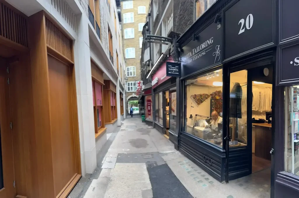 Tailor hand-crafting garments at sewing machine inside Arta Tailoring studio London